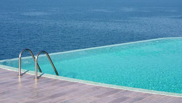 Pool with stairs with sea at background