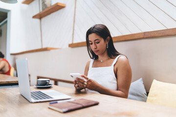 Concentrated businesswoman text messaging on mobile phone