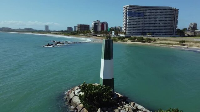 Nueva esparta bayside beach lighthouse, margarita island, venezuela. Tropical plam trees, chairs and awning beach, yacht and boats. Sunny day in the beautiful caribbean sea, atlantic ocean.