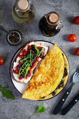 Fried omelet stuffed with mushrooms and sandwich with grilled peppers and caramelized onions. Top view