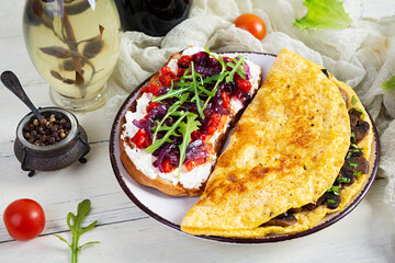 Fried omelet stuffed with mushrooms and sandwich with grilled peppers and caramelized onions