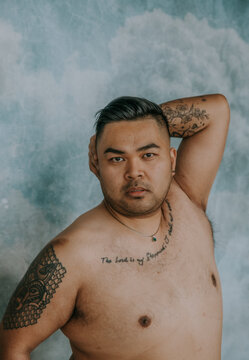 close-up of Filipino man with arm overhead looking at camera