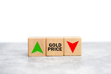 Wooden cubes with the word gold price and arrows pointing up and down. Changing gold price trend...