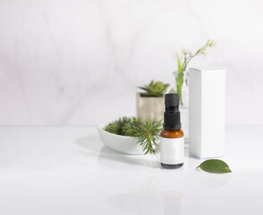 Mockup of amber colored glass bottle of cosmetic and facial care product, with its packaging box, with branches and green leaves