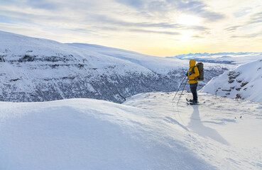 Fototapeta na wymiar Snow shoe hiking on a beautiful sunny day at a mountain peak of Dovrefjell