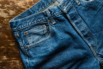 Worn and washed Japanese denim jeans with coin pocket, rivets and button fly