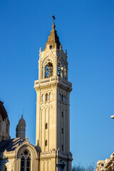Tower of the San Manuel y San Benito parish of Madrid, decorated and ornate tower at sunset with soft light, little contrast and blue sky.