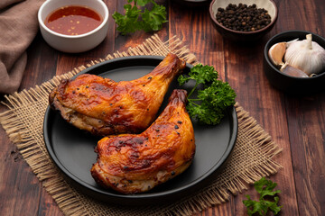 Air Fryer grilled chicken on black plate,served with chilli sauce