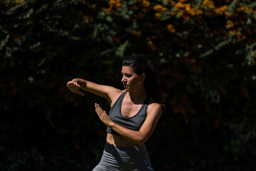 young and beautiful woman doing gymnastics in the garden of her house on a sunny day, yoga, diet, health
