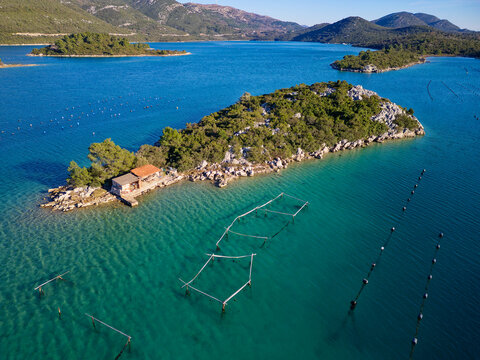Aerial drone view of the bay of Mali Ston located on Peljesac peninsula. Oyster farms in the turquoise sea water. Unique mix of freshwater and seawater.