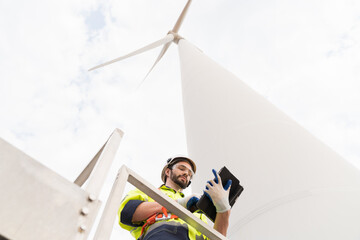 Male engineer working with plan inspecting or maintenance of wind turbines at windmill field farm....