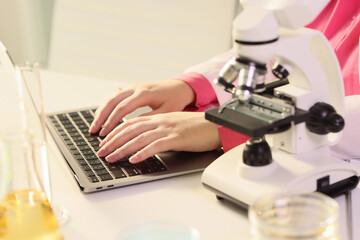 Female scientist working at laptop computer in research laboratory.