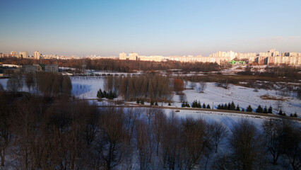 A winding bike path in a city park. City park in winter. Snow lies on the ground. Aerial photography.