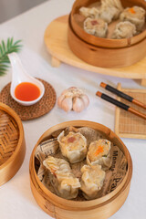 Tangerang Selatan, Indonesia - Feb 5, 2023: steamed three flavor dumpling dimsum in traditional bamboo steamer. 