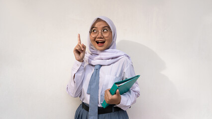 Female High School student in Indonesia with white and grey uniform with a notebook and was getting ideas. Isolated image on white background