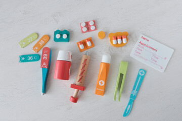 Medical toy plastic instruments on a light table. Doctor's first aid kit. Syringes, pills,...