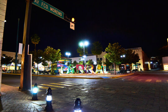 downtown at night, street in front of a park and sign with the name of the place, parral chihuahua 