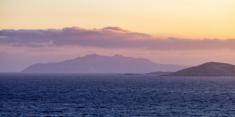 Rocky Island on Mediterranean Sea. Rinia near Mikonos, Greece, Europe. Nature Background. Sunrise Sky