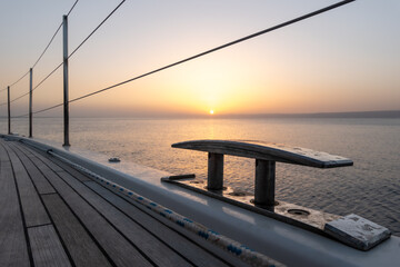 Railing and rope cleats of sailing yacht at sunset