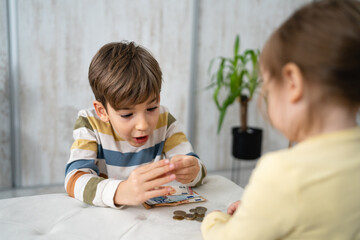 Siblings boy and girl small caucasian child brother and sister play at home with piggy bank saving money childhood investment insurance and finance concept copy space