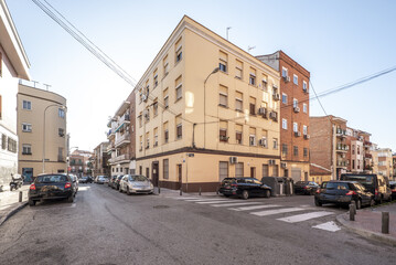 Naklejka na ściany i meble Facades of urban residential housing of modest construction at a crossroads with zebra crossings