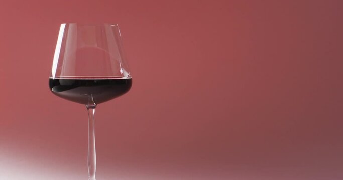 Glass of red wine standing over marsala background with copy space