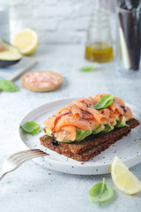 A rye bread sandwich with avocado and salmon	
