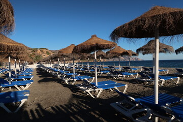 Fototapeta na wymiar Umbrellas on the beach of Nerja at Spains Costa del Sol