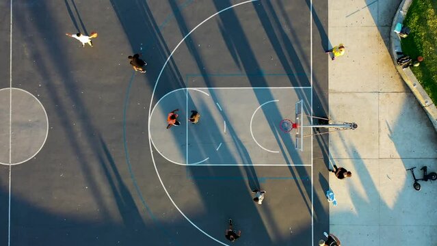 California, United States - 19 January 2023: Aerial view of people playing basketball along the beach at sunset, Venice Beach.