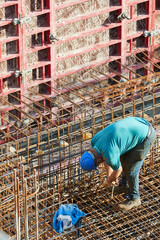 Arbeiter verbindet Stahlarmierung auf Baustelle für Stahlbeton