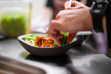chef hand cooking donburi food in the restaurant kitchen