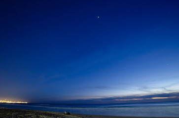 Obraz premium Night landscape with sea and sandy beach. Sunset sky with stars.