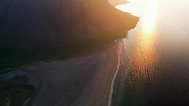 Aerial view of beautiful coastline with high cliffs at sunset facing the ocean at Tungurif Golden beach, Westfjord, Iceland.