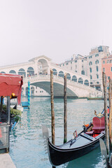 A gondola is docked in the blue water, waiting for its next passenger. In the background you can see the Rialto Bridge, whose stone shines white and invites you to stroll. © Miriam