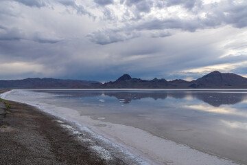 Scenic view of beautiful mountains reflecting in lake of Bonneville Salt Flats at sunset, Wendover, Western Utah, USA, America. Looking at summits of Silver Island Mountain range. Romantic atmosphere
