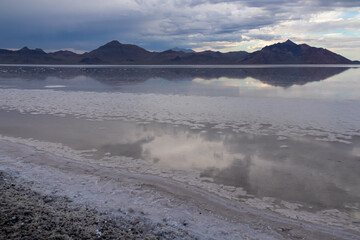 Scenic view of beautiful mountains reflecting in lake of Bonneville Salt Flats at sunset, Wendover, Western Utah, USA, America. Looking at summits of Silver Island Mountain range. Romantic atmosphere