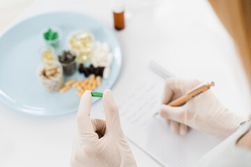 Nutritionist is writing prescription for biologically active supplements omega and zinc pills, antioxidants from aging, lecithin and adaptogen.