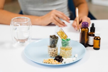 Nutritionist is writing prescription for biologically active supplements omega and zinc pills, antioxidants from aging, lecithin and adaptogen.