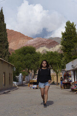 Fototapeta na wymiar Woman walking in a small town near the mountains