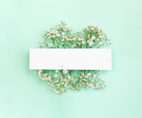Spring background.and discounts. Gypsophila on a light blue background.. White frame with small white flowers. Frame for invitations, wedding or greeting cards or for your design.