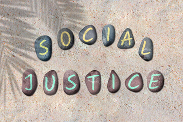 World day of Social Justice creative poster illustrated by round stone on a beach sand.