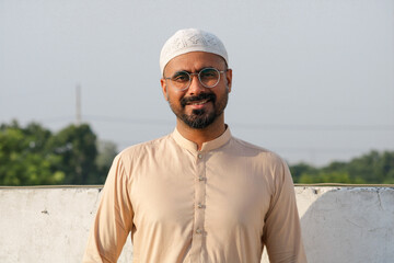 Young middle aged guy wearing Muslim cap. Young energetic muslim guy looking in the camera while smiling. 