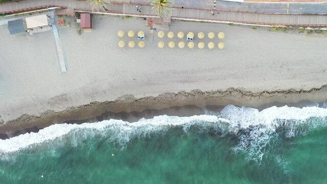 Aerial view of parasols on the beach in Costa del Sol coastline, Malaga, Andalusia, Spain.