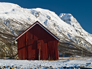 Old boatshed against winter mountains