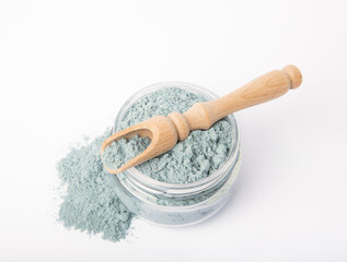 Blue spirulina powder in glass jar and spoon isolated on white background. Natural vegan superfood. Food supplement. Phycocyanin extract.