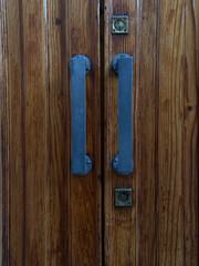 Old wooden door with blue handles
