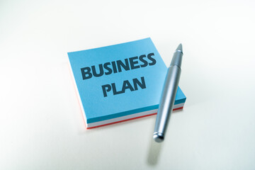 Business plan word write in a blue post it. Strategy concept. Management process concept.
