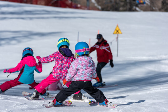 Maestro di sci insegna a gruppo di bambini