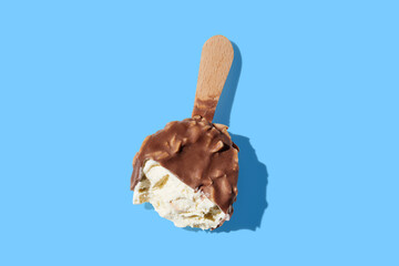 chocolate ice cream on a stick on blue pastel background