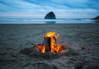 Inviting campfire on Cape Kiwanda Beach with haystack rock during the summer near Pacific City in...